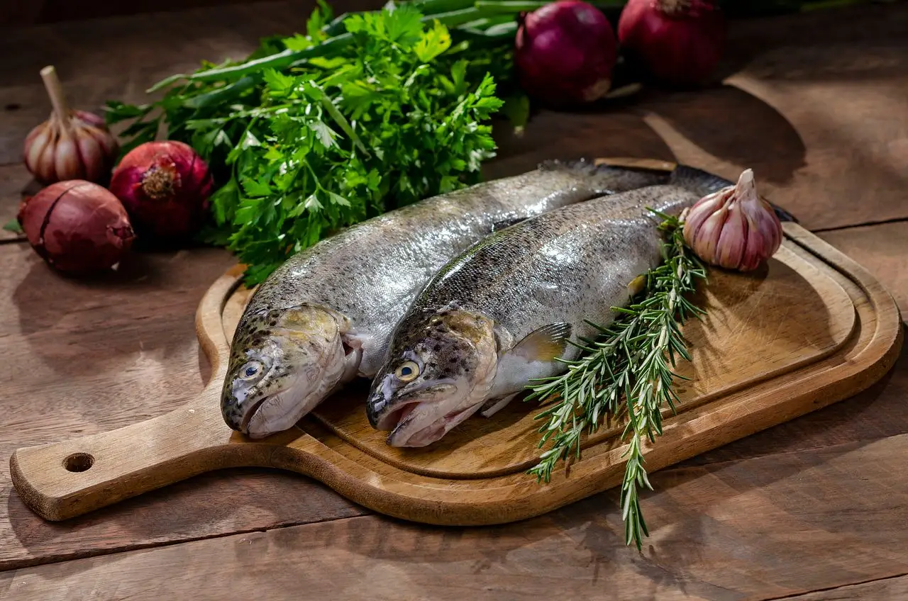 Poisson entier frais sur une table de cuisine, lumière naturelle
