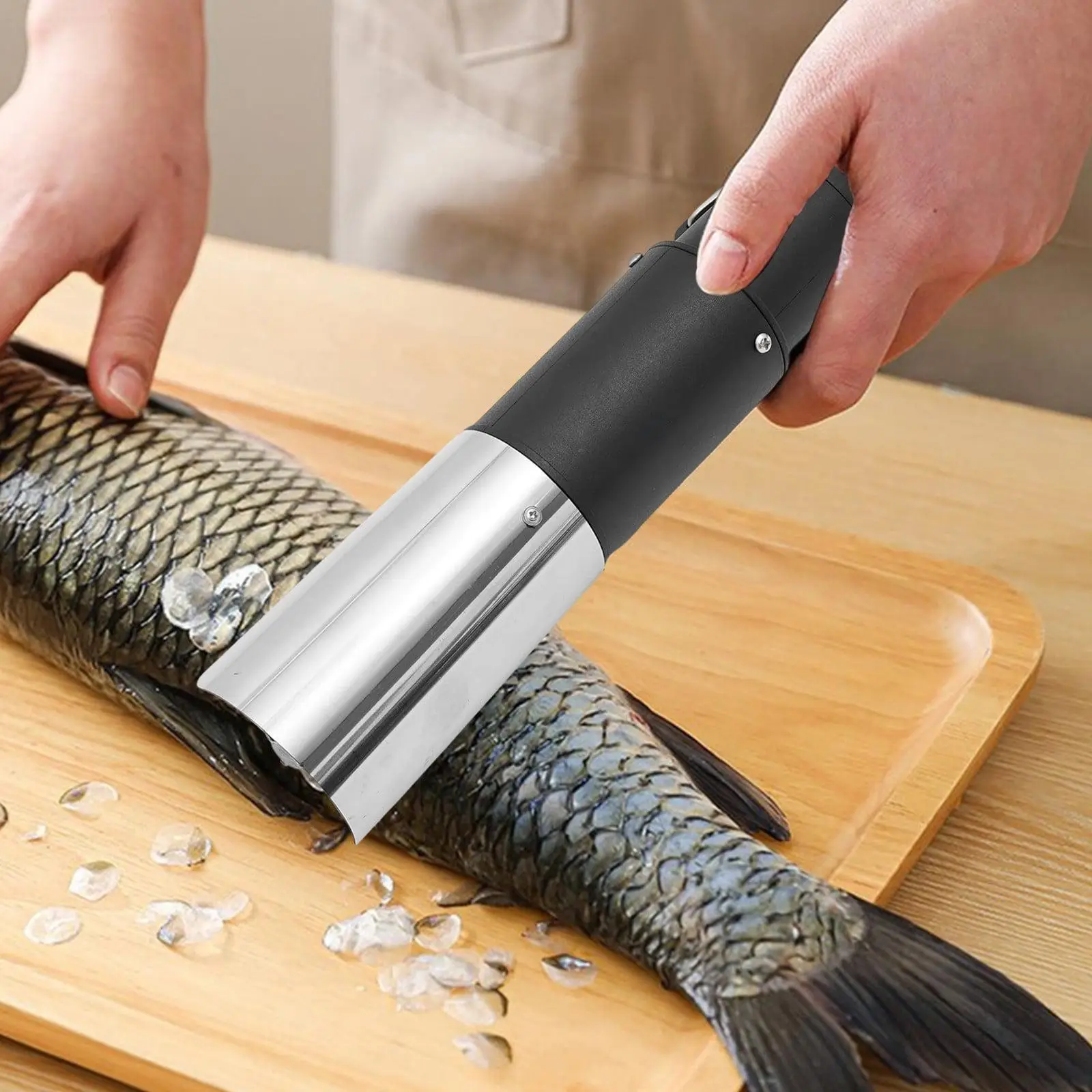 Écailleur électrique appliqué avec soin sur les flancs d’un poisson entier